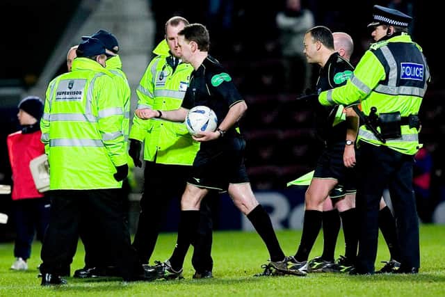 Referee Hugh Dallas and linesman Andy Davis are escorted off by the police at the end of the game. Picture: SNS