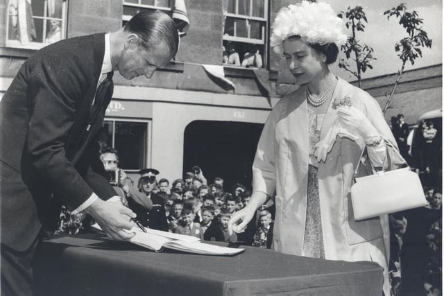The Queen and the Duke of Edinburgh sign the visitors book while in Dalkeith. Photo courtesy Midlothian Council Local Studies