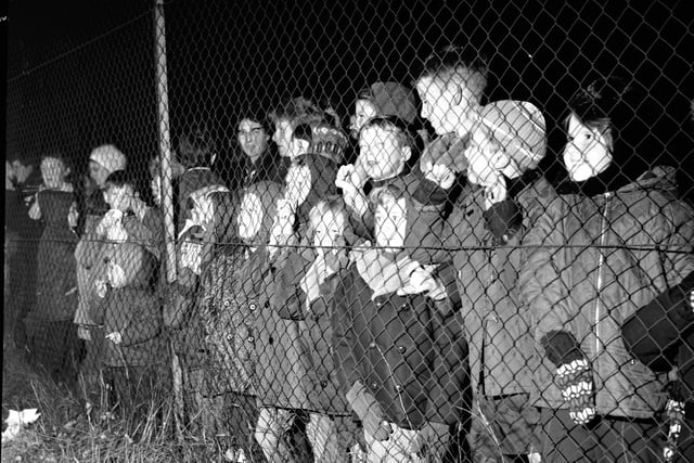 Children are kept safe behind a chain link fence at an organised bonfire and firework show staged at Redford Barracks in Edinburgh in November 1968
