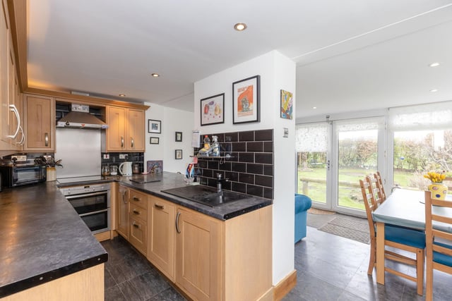 The modern fitted kitchen with appliances which is open plan to the large and bright sunroom with French doors to the rear garden.