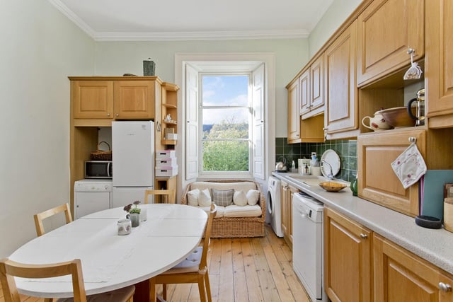 The kitchen's base cabinets are accompanied by spacious worktops and splashback tiling.
