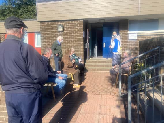 Residents outside the health centre were given chairs to wait in.