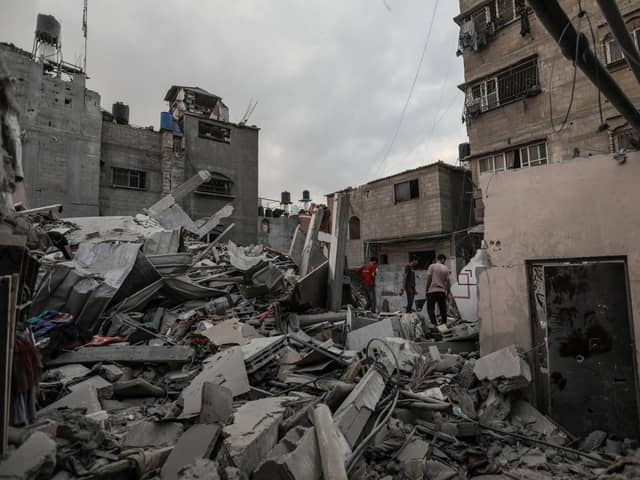 People in Khan Yunis, Gaza, search through the rubble of buildings destroyed during Israeli air strikes. Picture: Ahmad Hasaballah/Getty Images.