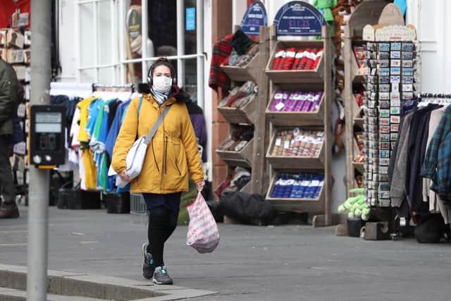 A woman wearing a face mask in Edinburgh, the day after Prime Minister Boris Johnson called on people to stay away from pubs, clubs and theatres, work from home if possible and avoid all non-essential contacts and travel in order to reduce the impact of the coronavirus pandemic (Picture: Andrew Milligan/PA Wire)
