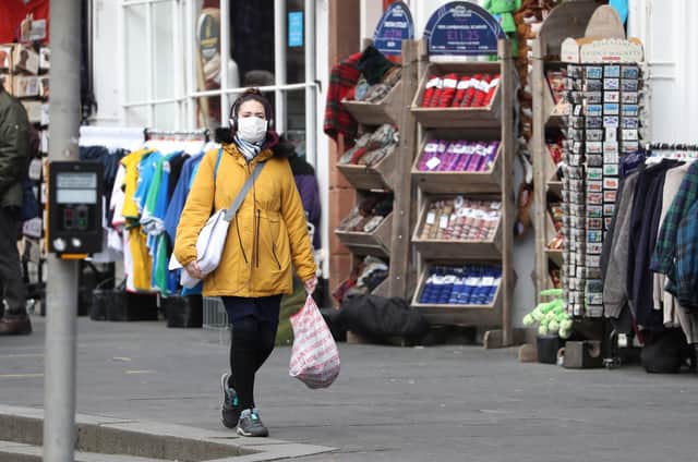 A woman wearing a face mask in Edinburgh, the day after Prime Minister Boris Johnson called on people to stay away from pubs, clubs and theatres, work from home if possible and avoid all non-essential contacts and travel in order to reduce the impact of the coronavirus pandemic (Picture: Andrew Milligan/PA Wire)