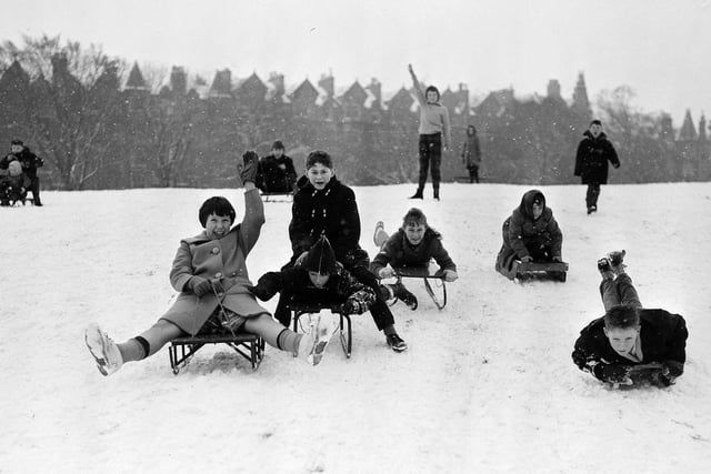 Children are enjoying the snow by sledging in The Meadows. Warrender Park Terrace can be seen in the background. Year: 1961