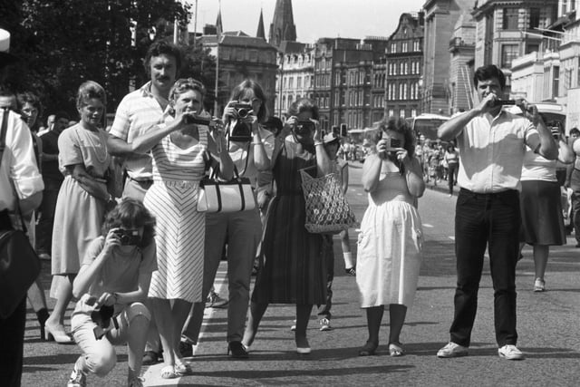 Tourists taking photographs of the Royal Scots Guards as they marched along Princes Street in July 1984.
