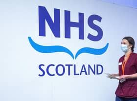 A member of the vaccination team walks past an NHS sign at the coronavirus mass vaccine centre at the Edinburgh International Conference Centre earlier this year. Picture: Jane Barlow - Pool/Getty Images
