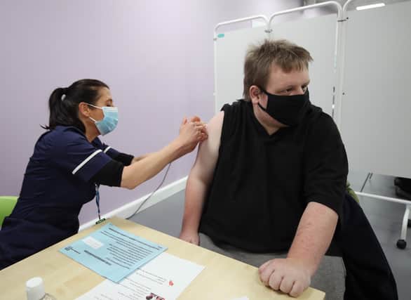 Gavin Howcroft, aged 30, who has the learning disability global developmental delay (GDD), receiving the Oxford/Astra Zeneca Covid-19 vaccine from Suzie Shakespeare, Senior Immunisation Nurse, during a mass vaccination of members of the public at Robertson House, Stevenage. Picture date: Tuesday February 9, 2021.