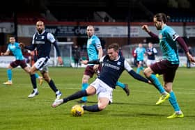 Dundee's Lee Ashcroft slides in on Hearts' Peter Haring at Dens Park.