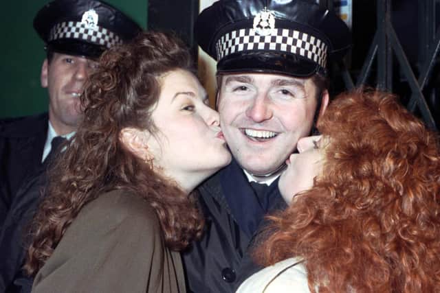 Two women smooch a police officer at Edinburgh Hogmanay celebrations in 1990.