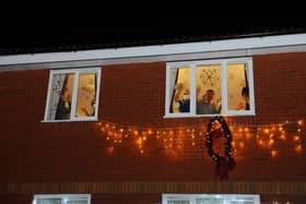 People wave from inside a care home during the Christmas period (Picture: Michael Gillen)