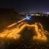 Torch bearers creating the 'Be Together' symbol in Holyrood Park, following the annual torchlight procession through Edinburgh
