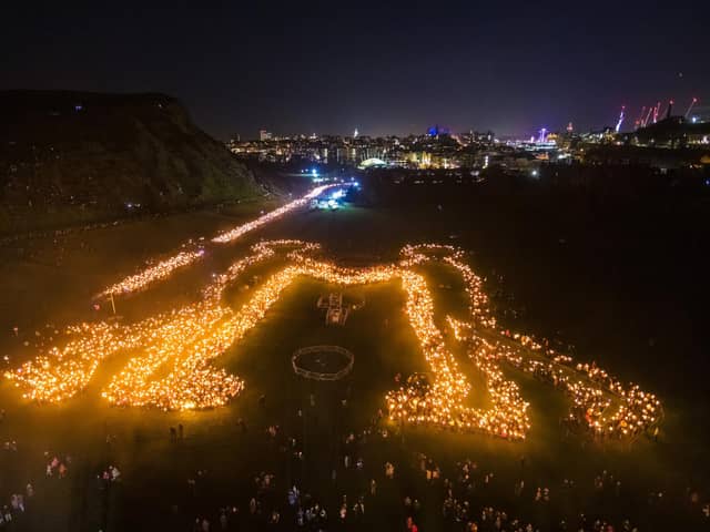 Torch bearers creating the 'Be Together' symbol in Holyrood Park, following the annual torchlight procession through Edinburgh