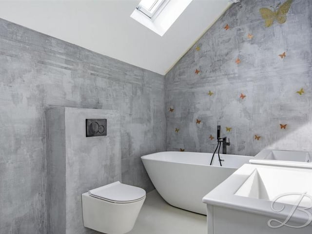 All five bedrooms have en suite facilities. The ones pictured comprise a low-flush WC, two wall-hung vanity units, a free-standing bath, a walk-in shower and two Velux roof windows.