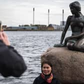 Tourists photograph themselves with the famous Little Mermaid statue at the harbour in Copenhagen (Picture: Odd Andersen/AFP via Getty Images)