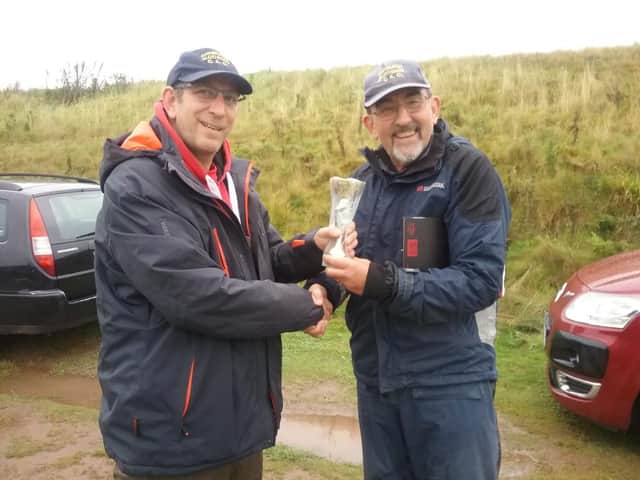 Chris Bolton (left) is presented with the Rod and Reel Only Cup by Geoffrey Lowe.