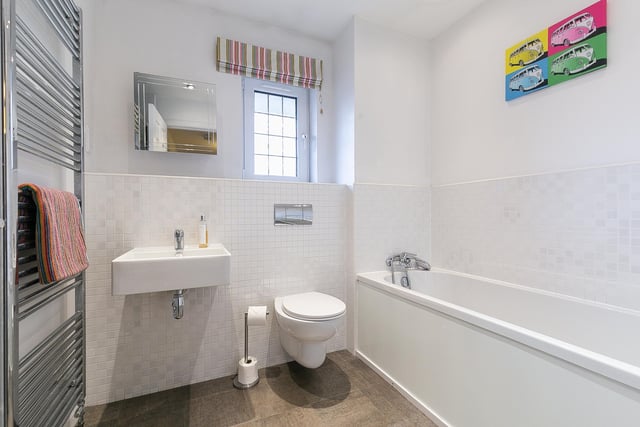The family-size bathroom is fitted with a three-piece suite, tiled splash walls and a ladder-style radiator.