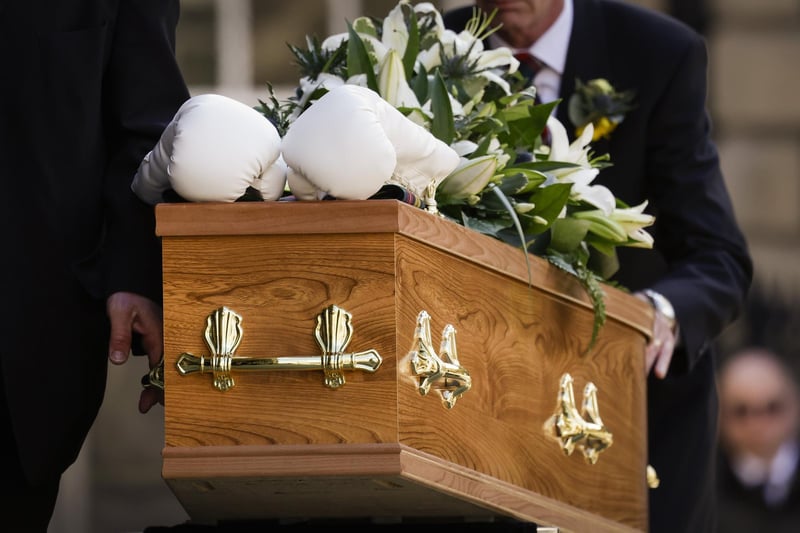 White boxing gloves lie on the coffin as it arrives for the funeral ceremony