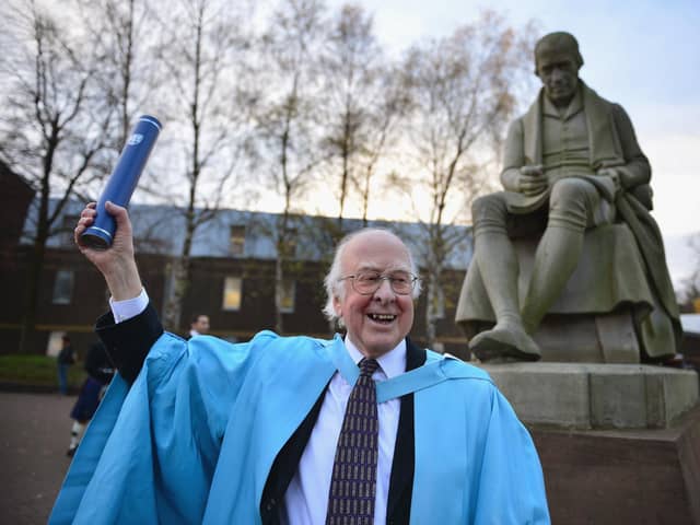 The late Professor Peter Higgs poses for photographs in front of a statue of James Watt, after receiving an honorary degree from Heriot-Watt University in 2012 (Picture: Jeff J Mitchell/Getty Images)