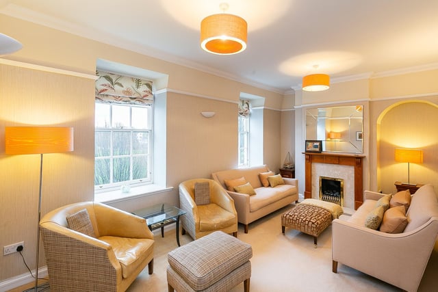 Set to the front, the southerly-facing living room allows plentiful natural light and features a living flame gas fire with a tasteful surround, carpeted flooring, two light pendants, uplights and ample space for freestanding furniture.