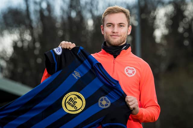 Nathaniel Atkinson holds the special Big Hearts addition of the third kit which Hearts will wear against Livingston on Saturday. Picture: SNS