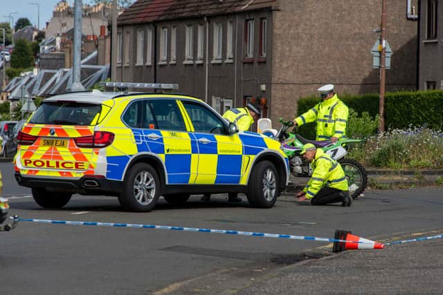 Police officer closely examine the scene at Smokey Brae in Edinburgh