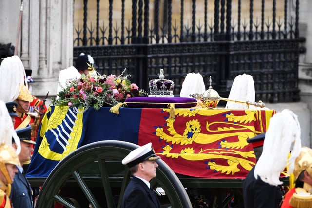The State Gun Carriage carries the coffin of Queen Elizabeth II, draped in the Royal Standard with the Imperial State Crown and the Sovereign's orb and sceptre, in the Ceremonial Procession following her State Funeral at Westminster Abbey. Alain Jocard/PA Wire