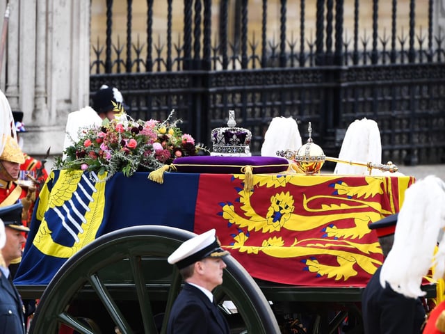 The State Gun Carriage carries the coffin of Queen Elizabeth II, draped in the Royal Standard with the Imperial State Crown and the Sovereign's orb and sceptre, in the Ceremonial Procession following her State Funeral at Westminster Abbey. Alain Jocard/PA Wire