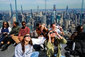 People look toward the sky at the Edge at Hudson Yards observation deck ahead of the total solar eclipse in New York City. While people overseas were losing their minds over the sun blacking out, all of Scotland was praying for the sun to actually shine in the first place, says Vladimir McTavish. (Picture: Charly Triballeau/Getty Images)