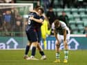 Goalscorers Alex Iacovitti and Goerge Harmon celebrate as a dejected Chris Cadden bows his head following Ross County's 2-0 win over Hibs. Picture: SNS