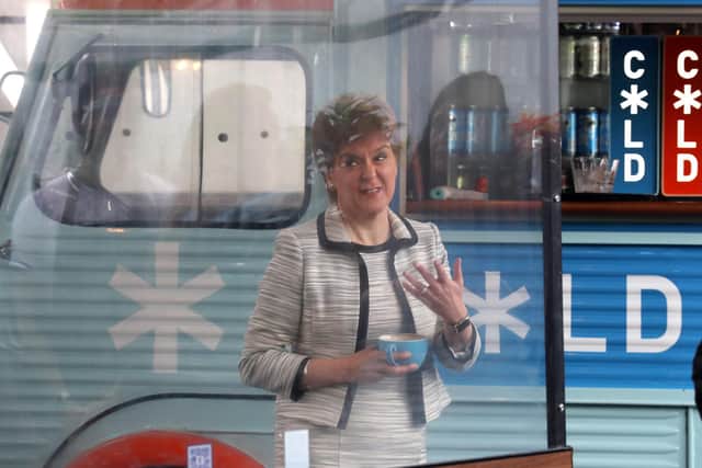 First Minister Nicola Sturgeon beside a screen which was been erected around tables during a visit to Cold Town House in Edinburgh's Grassmarket in July 2020.