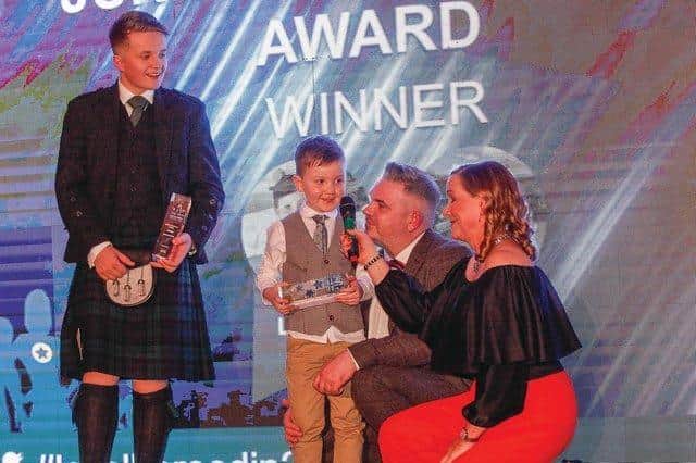Andrew and Logan with the other Evening News Local Hero Award winner Michael Reilly picking up their junior local hero award from Arlene Stuart.