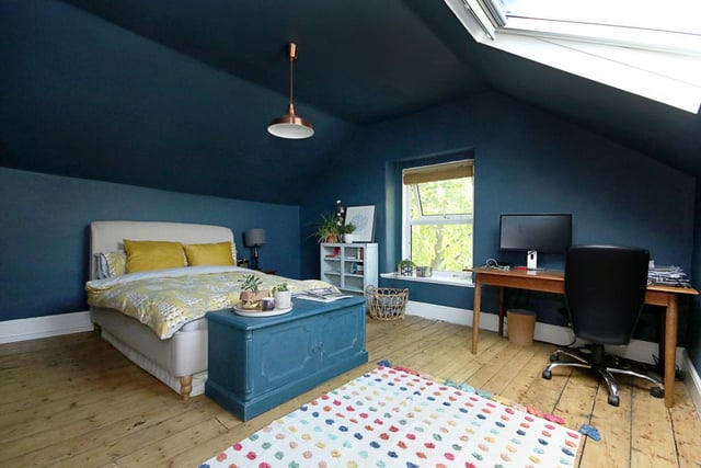 This is the attic bedroom, featuring stripped floorboards and a modern skylight.
