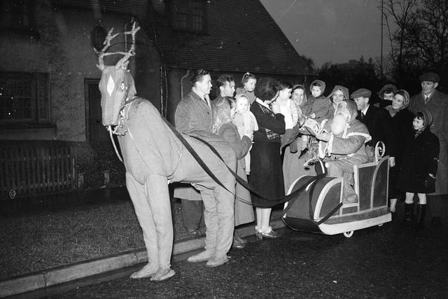 Santa and pantomine reindeer distribute presents in Muirhouse's Pennywell Road in December 1953.