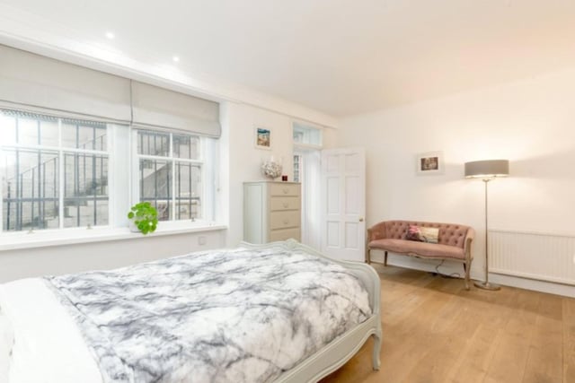 The spacious principal bedroom is situated on the lower floor with direct access to a shared front courtyard and a stairway leading to street level