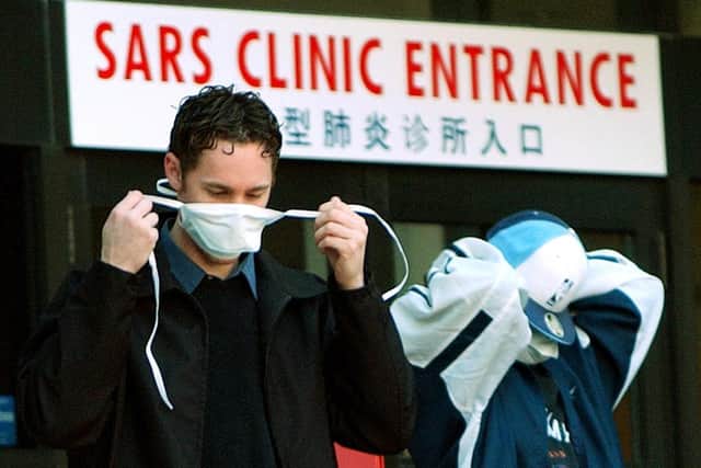 Patients put on face masks as they leave a SARS (Severe Acute Respiratory Syndrome) in Toronto, Canada in 2003 (Photo: J.P. MOCZULSKI/AFP via Getty Images)