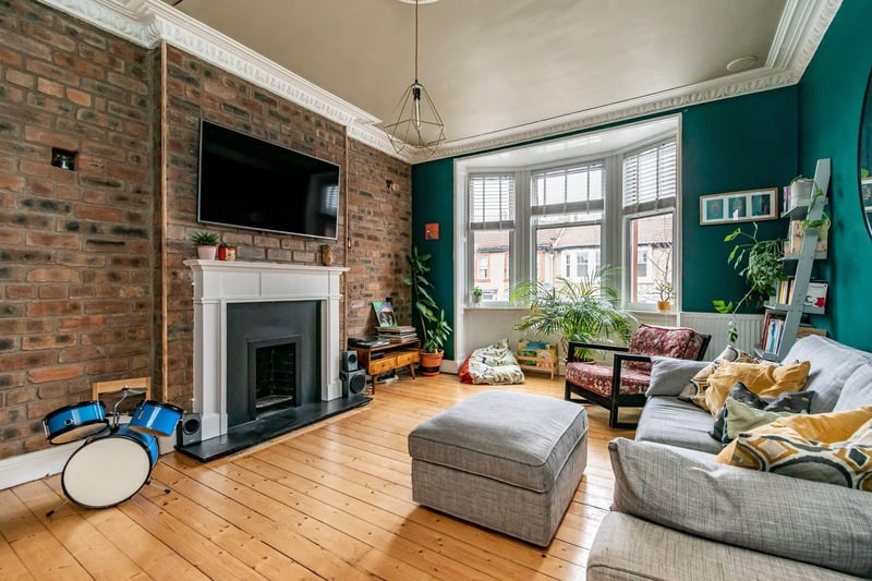 The spacious living room benefits from great natural light and an original fireplace