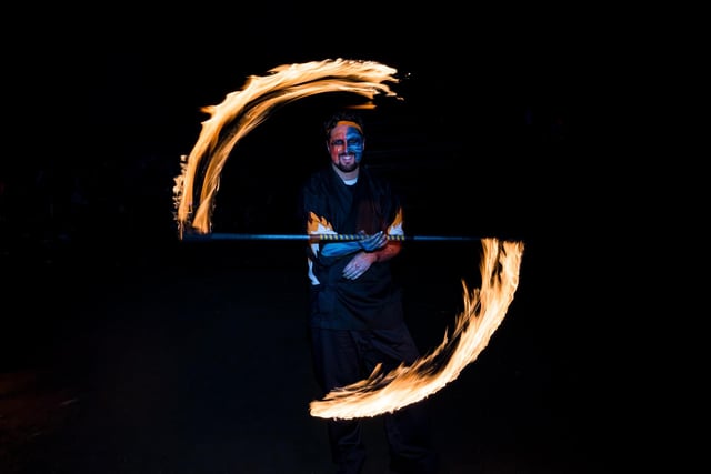 A performer smiles widely, as he plays with fire at the 2023 Beltane Fire Festival. The name of the festival, Beltane, is thought to have derived from a Celtic word meaning 'bright fire'.
