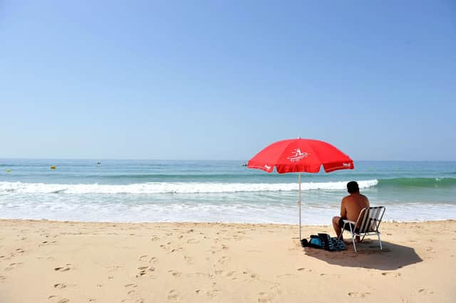 File photo dated 12/06/14 of a man sitting under a parasol on the beach at Praia da Luz, Portugal. Moving Portugal off the UK's green list is "an overreaction", an epidemiologist in the popular holiday destination has claimed. Issue date: Friday June 4, 2021. PA Photo. Professor Henrique Barros, president of Portugal's National Health Council, said the country's overall coronavirus situation is "relatively stable". He made the comments after Communities Secretary Robert Jenrick said positive cases had doubled in the last three weeks in Portugal. See PA story HEALTH Coronavirus. Photo credit should read: Nick Ansell/PA Wire