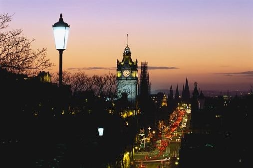 Photo taken in 1998 of street lights and traffic light up Princes Street in Edinburgh. In the center is the clock tower of the Balmoral Hotel.