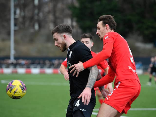 Lee Hamilton tussles with Falkirk's Liam Henderson. Picture: Dave Johnston.
