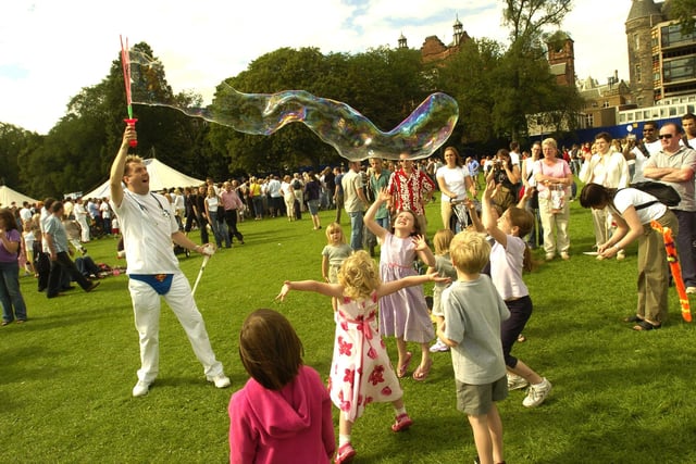 The Meadows is a popular place to be during the Edinburgh Festival Fringe - here we can see Andy Train taking time out from his Fringe comedy show to create some huge bubbles for children. Year: 2004