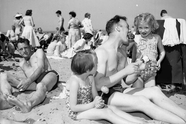 Edinburgh Trades holiday makers at Portobello beach in July 1958. Mr W Devon, Caroline Devon and Linda Gillespie are enjoying toffee apples.
