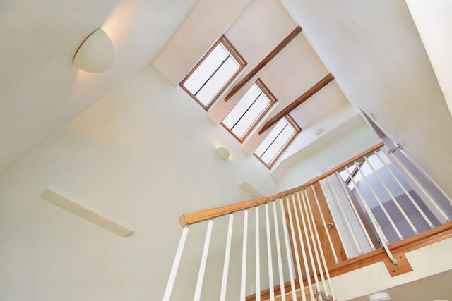 The bespoke feature stairway with motorised Velux windows, offering an abundance of natural light.