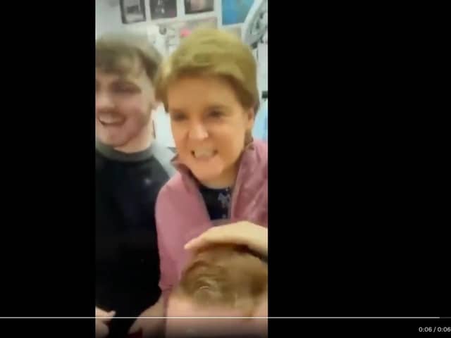 The video shows Nicola Sturgeon not wearing a face mask in a public setting.