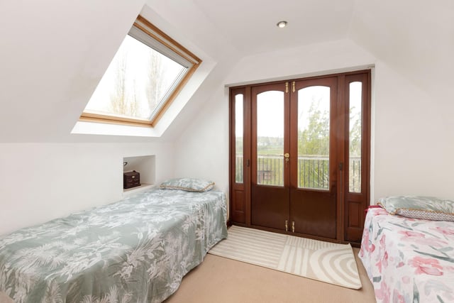 The upstairs double bedroom in the converted workshop has access to a balcony.