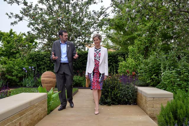 Sophie, Countess of Wessex (R), listens to garden designer Adam Frost (L) in the Homebase Garden during a visit to the Chelsea Flower Show in London in 2013. Pic: BEN STANSALL/AFP via Getty Images)