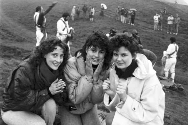 Three girls wash their face in the morning dew at the top of Arthur's Seat during the traditional May Day ceremony in Edinburgh, 1987.