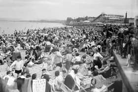 Crowds of holiday-makers cram onto Portobello Beach in May 1952 with the rollercoaster and funfair in the background.